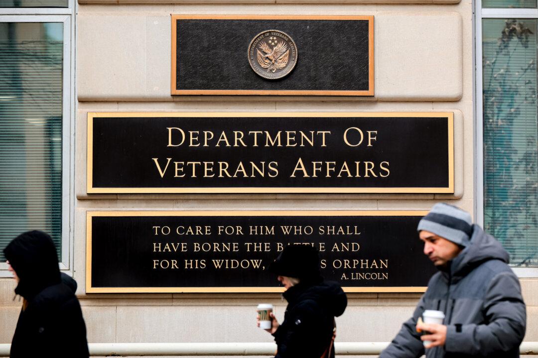People walk past the Department of Veterans Affairs headquarters, a block from the White House, in Washington on March 6, 2025. Veterans Affairs Secretary Doug Collins said the department will cut its workforce by 15 percent—about 80,000 jobs—under President Donald Trump's directive to downsize the federal government. (Chip Somodevilla/Getty Images)