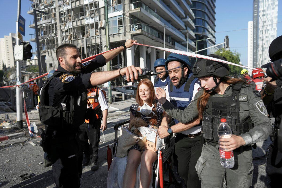 A woman is evacuated from the site of a direct hit from an Iranian missile strike in Ramat Gan, Israel, on June 19, 2025. (Oded Balilty/AP)