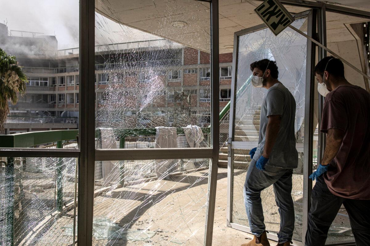 Emergency workers walk through a destroyed door at a building at Soroka Hospital after the facility was struck by an Iranian missile in Beersheba in southern Israel on June 19, 2025. (John Wessels/AFP via Getty Images)