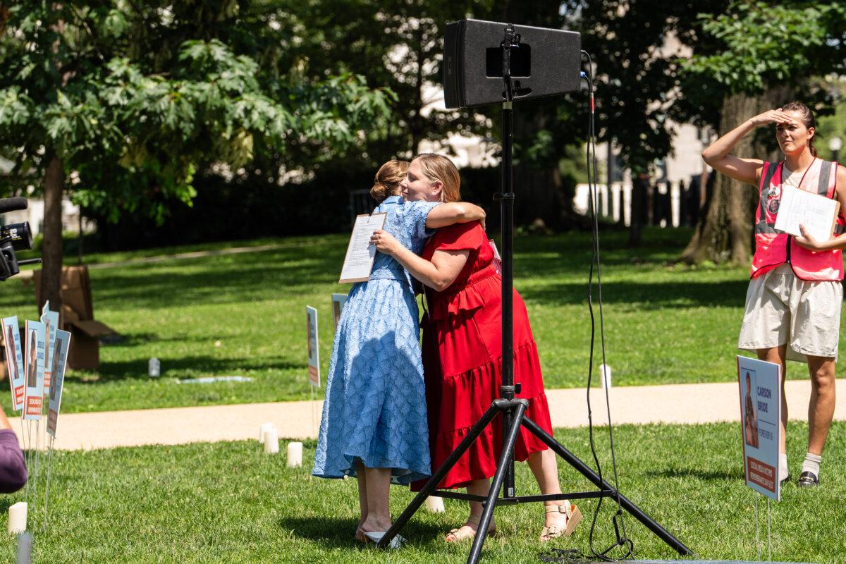 Kristin Bride (L), mother of 16-year-old Carson Bride who died by suicide after being cyberbullied online, hugs Amy Neville (R), mother to 14-year-old Alexander Neville who died from fentanyl poisoning from a pill he purchased on Snapchat, after speaking during Social Media Victims Remembrance Day at the Upper Senate Park on Capitol Hill in Washington on June 23, 2025. (Madalina Kilroy/The Epoch Times)