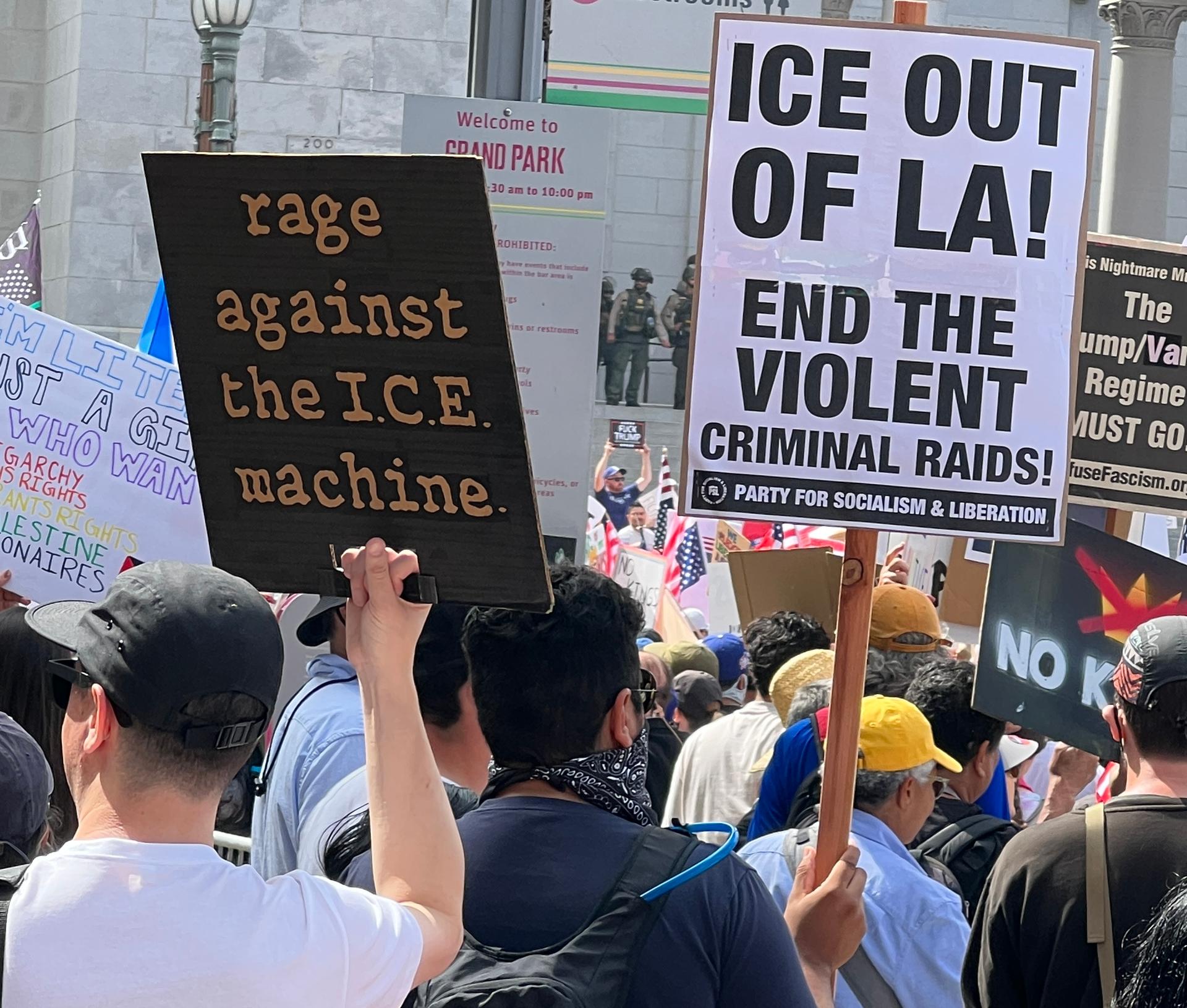 A protester carries a black-and-white Party for Socialist and Liberation (PSL) sign at the No Kings protest at Los Angeles City Hall on June 14, 2025. (Brad Jones/The Epoch Times)