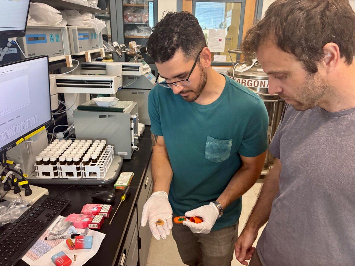 Researchers Mark Salazar (L) and Brett Poulin in a lab with disposable vape pods. (Courtesy of Kat Kerlin, UC Davis)