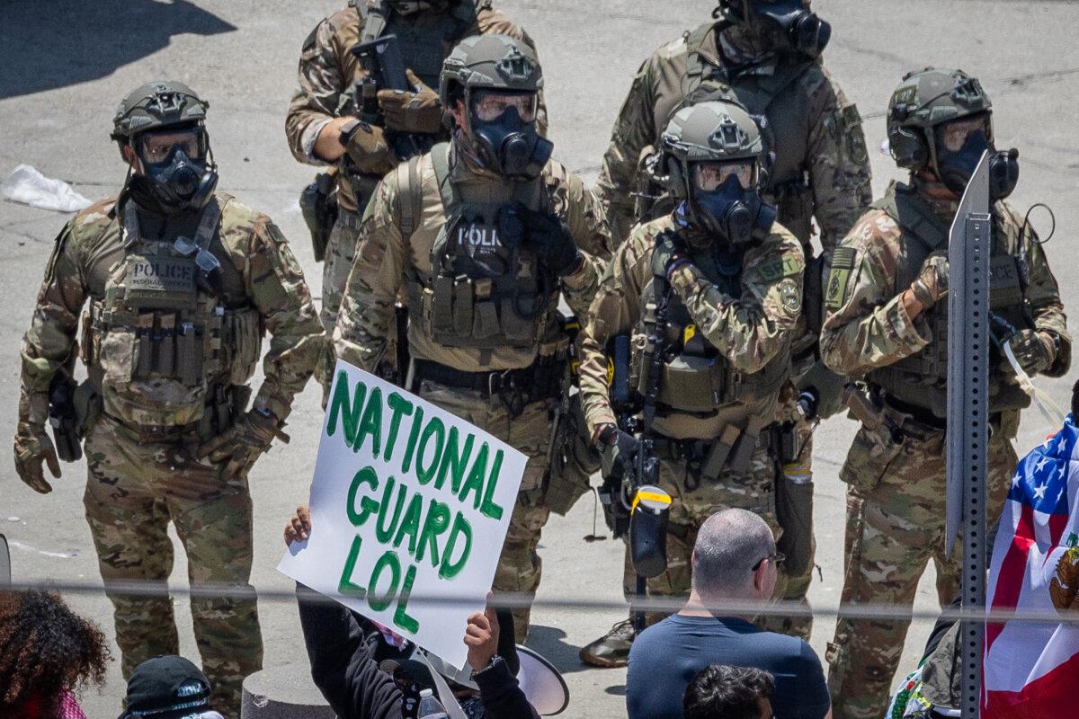 ICE agents form a defensive perimeter near an operations center in Los Angeles on June 8, 2025. (John Fredricks/The Epoch Times)