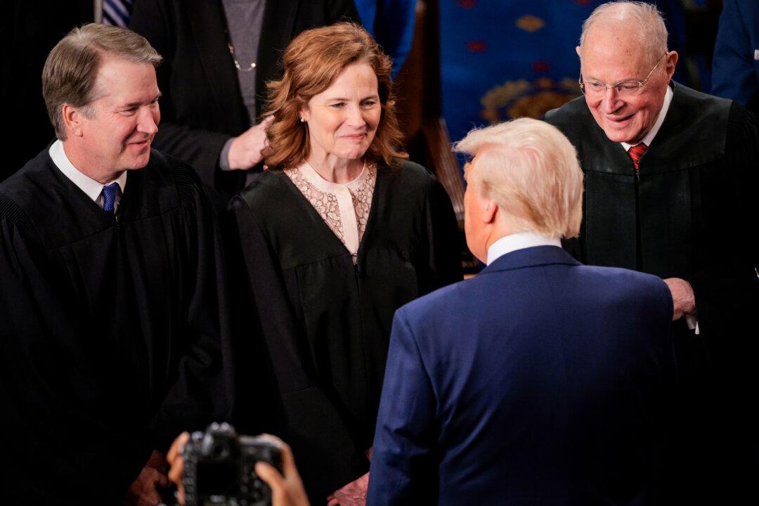 (L–R) Supreme Court Associate Justices Brett Kavanaugh, Amy Coney Barrett, and former Associate Justice Anthony Kennedy talk with President Donald Trump as he arrives to address a joint session of Congress at the U.S. Capitol on March 4, 2025. (Chip Somodevilla/Getty Images)