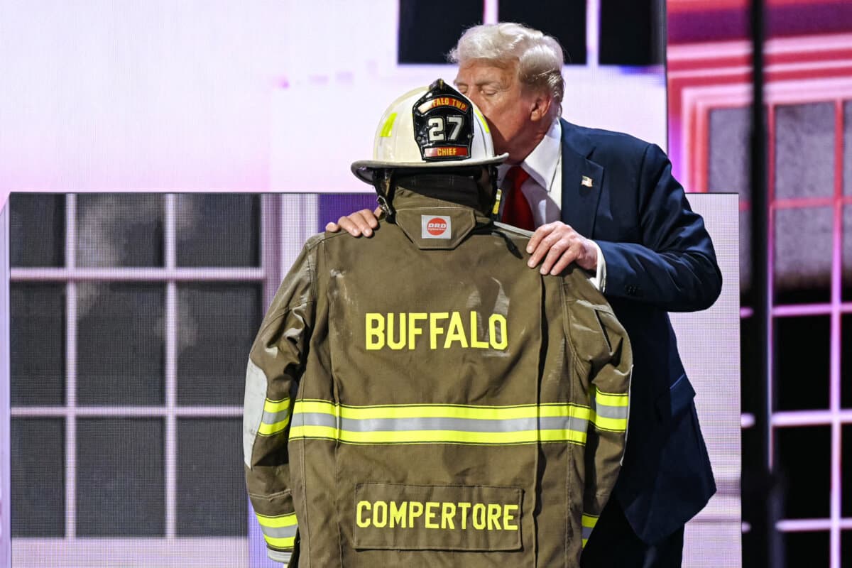 Then former President Donald Trump kisses a helmet and firefighter’s jacket that belonged to Corey Comperatore as he takes the stage to accept the Republican nomination at the Fiserv Forum on the final day of the 2024 Republican National Convention in Milwaukee on July 18, 2024. (Patrick T. Fallon/AFP via Getty Images)
