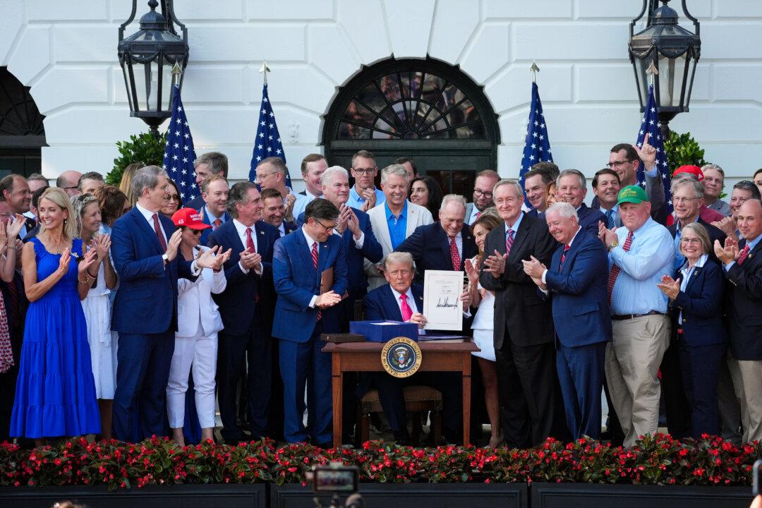 President Donald Trump signs his signature bill of tax breaks and spending cuts at the White House in Washington, surrounded by members of Congress, on July 4, 2025. (AP Photo/Evan Vucci)