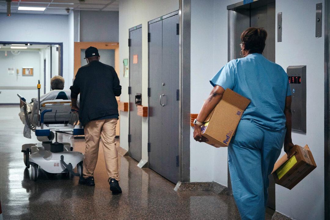 A nurse transports a patient on a stretcher inside Brookdale University Hospital and Medical Center in New York, on July 1, 2025. (AP Photo/Andres Kudacki)