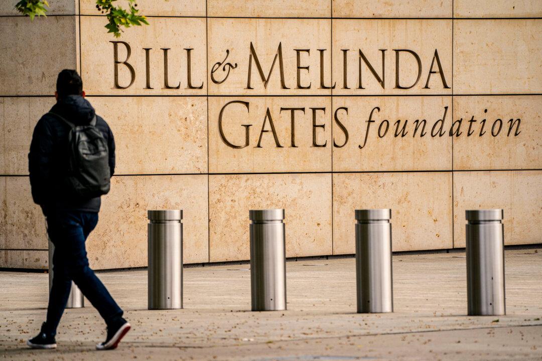 A pedestrian walks past the Bill and Melinda Gates Foundation in Seattle on May 4, 2021. The Gates Foundation is the WHO’s second-largest overall donor after the United States. Critics say the organization has shifted from promoting community-based health measures—such as nutrition and sanitation—to favoring commodity-based disease responses, such as vaccines, driven by a centralized bureaucracy. (David Ryder/Getty Images)