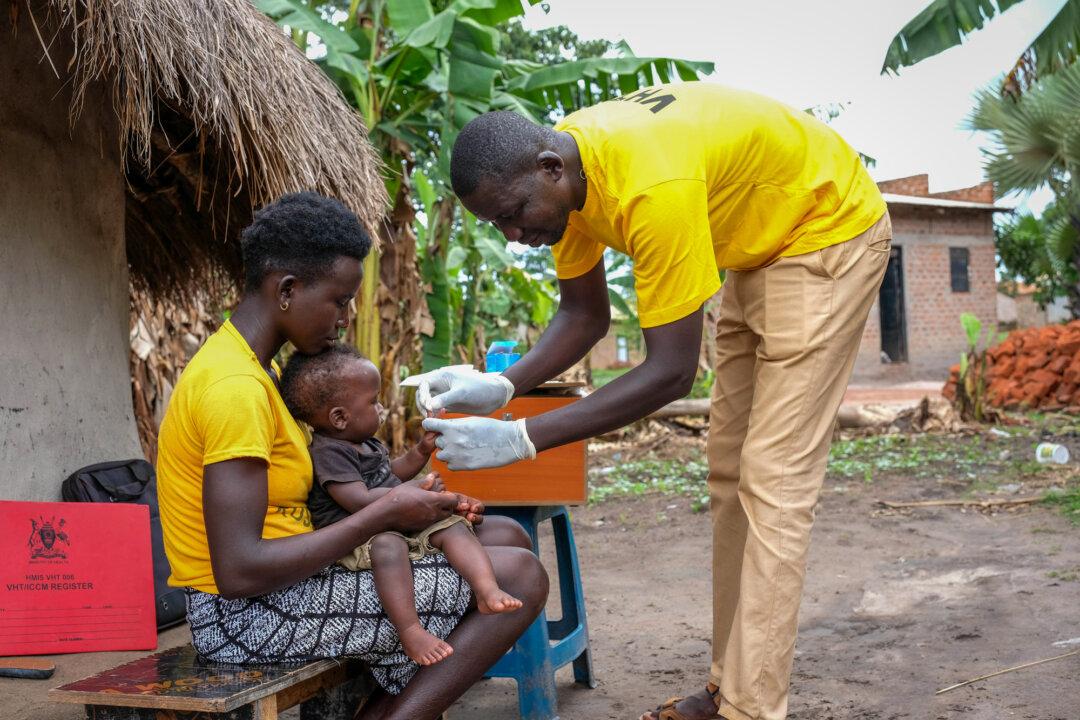 A health officer takes a blood sample from a baby for a malaria rapid diagnostic test after educating community members about the malaria vaccine in Apac District, Uganda, on April 7, 2025. The WHO says diseases linked to “poverty and marginalization”—such as tuberculosis, HIV, and malaria—still kill more than 2 million people annually. Critics say the organization has not devoted enough resources to address these issues. (Hajarah Nalwadda/Getty Images)