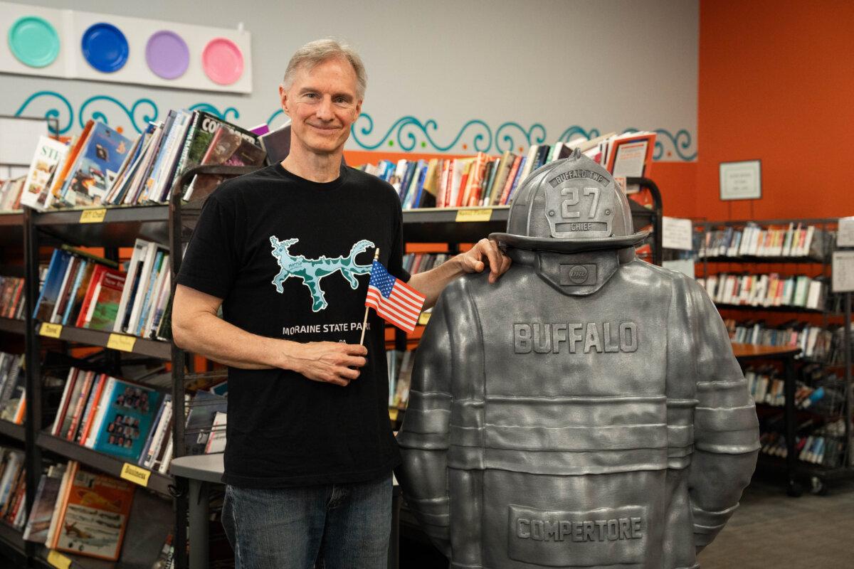 Christopher Tomko stands next to his sculpture of Corey Comperatore’s turnout gear at South Butler Community Library in Saxonburg, Pa., on July 12, 2025. (Samira Bouaou/The Epoch Times)