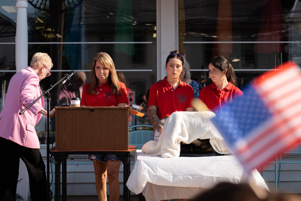 Helen Comperatore and daughters Kaylee (C) and Allyson dedicate a sculpture at South Butler Community Library in Saxonburg, Pa., on July 12, 2025. (Samira Bouaou/The Epoch Times)