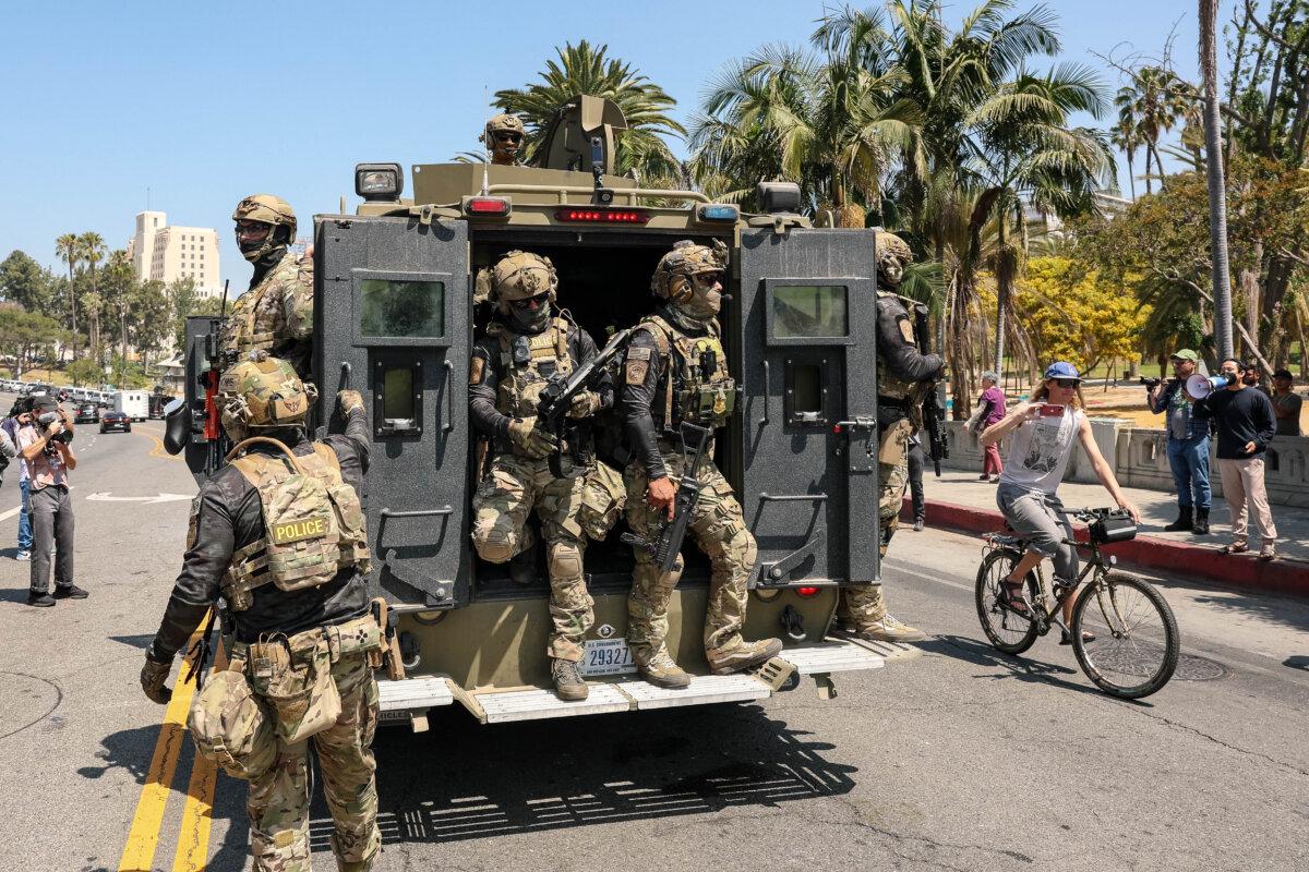 Federal agents with US Customs and Border Patrol (CBP) ride on an armored vehicle driving slowly down Wilshire Boulevard in Los Angeles, Calif., on July 7, 2025. (Patrick T. Fallon/AFP)
