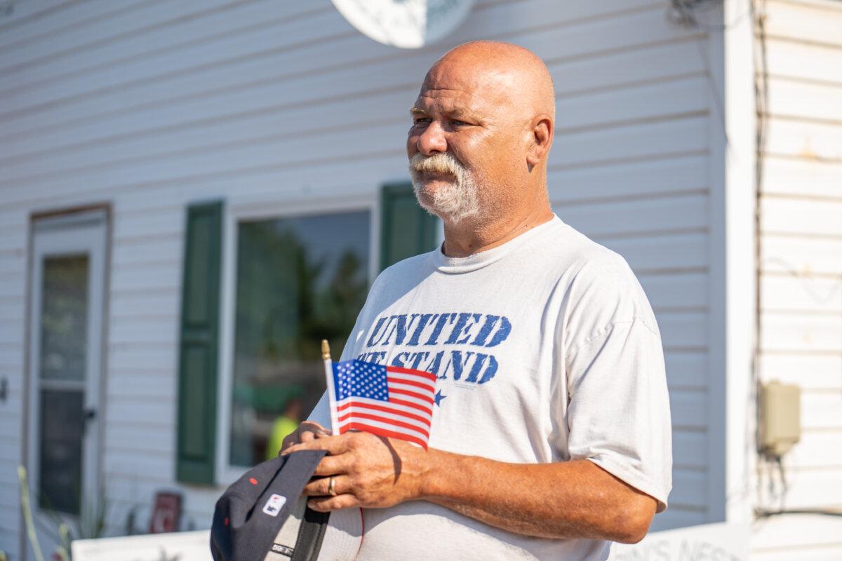 A man watches Helen Comperatore and daughters Allyson and Kaylee taking part in a parade in memory of Corey Comperatore near Butler, Pa., on July 12, 2025. (Samira Bouaou/The Epoch Times)