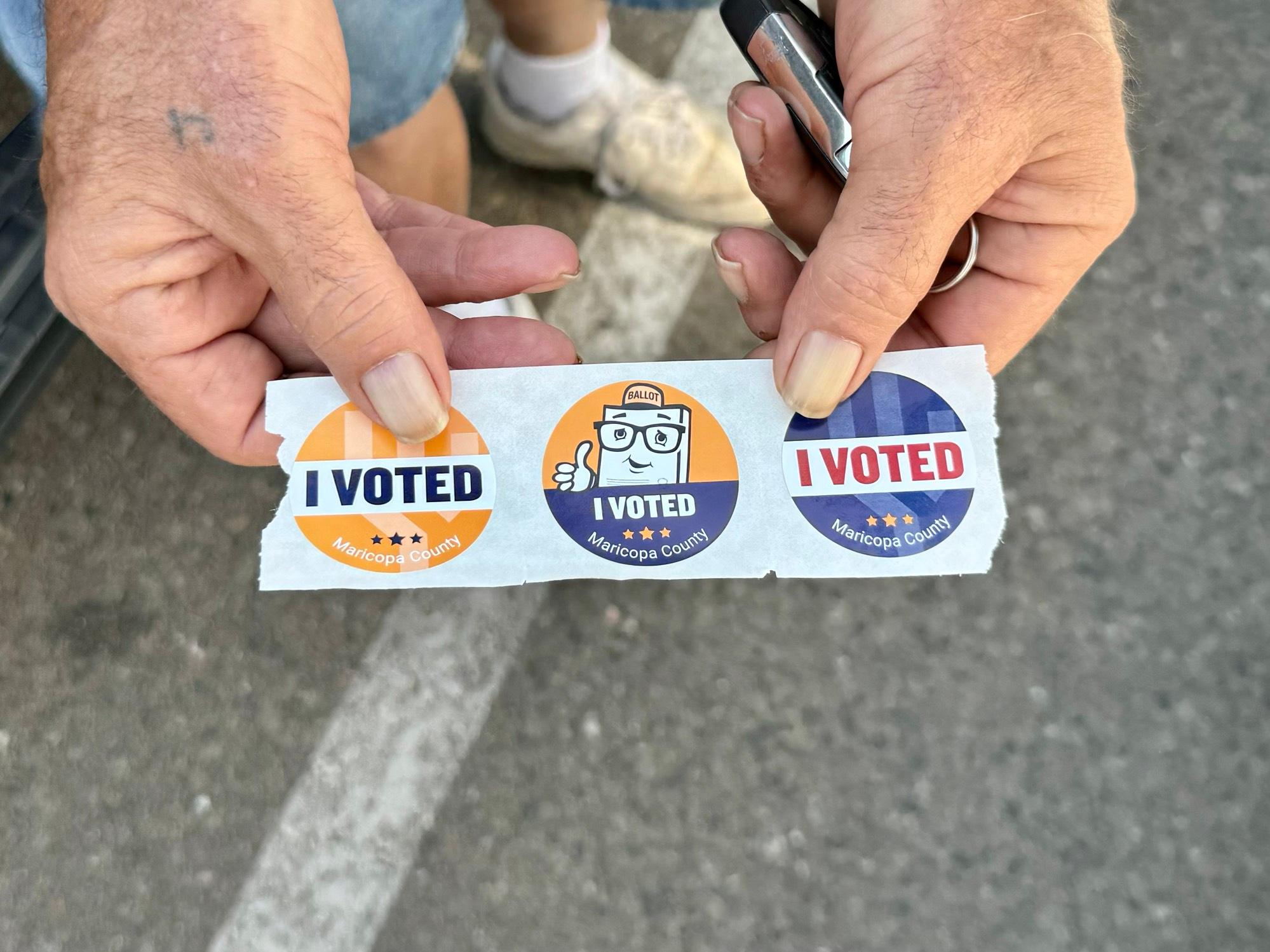 Jerry, a voter in Maricopa County, Ariz., shows his 'I Voted' stickers after depositing a ballot at Towson City Hall on July 14, 2025. (Arjun Singh/The Epoch Times)
