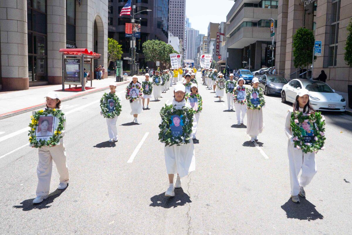 Falun Gong practitioners hold photos of persecuted victims while marching in a parade in San Francisco on July 12, 2025. (Gary Wang/The Epoch Times)
