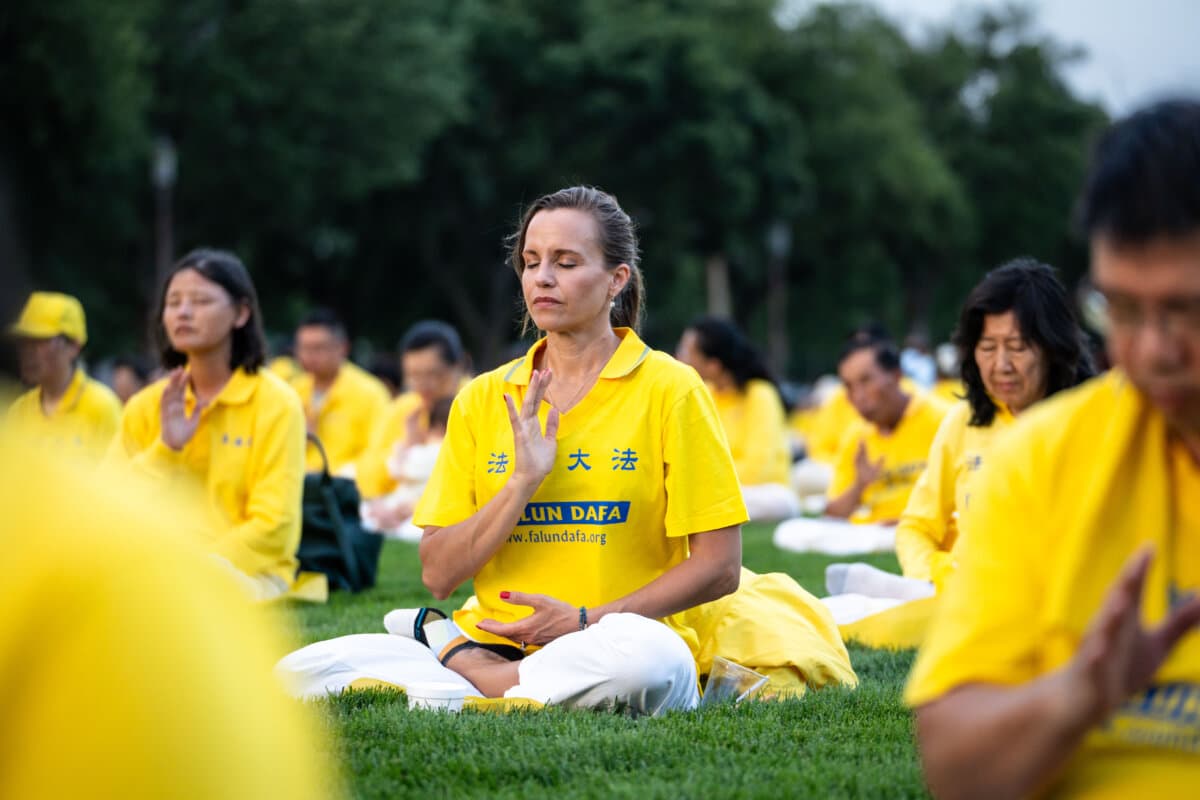 Falun Dafa practitioners practice exercises before taking part in a candlelight vigil commemorating Falun Gong practitioners who were persecuted to death by the Chinese Communist Party in China, in Washington on July 17, 2025. (Madalina Kilroy/The Epoch Times)