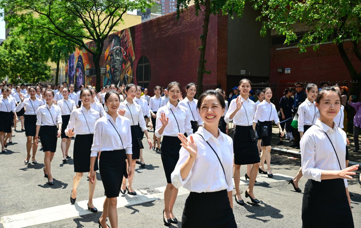 Shen Yun Performing Arts performers smile and wave to members of the public who gave the group a warm welcome as it participates in a march in New York City on July 20, 2025. (Courtesy of Adhiraj Chakrabarti)