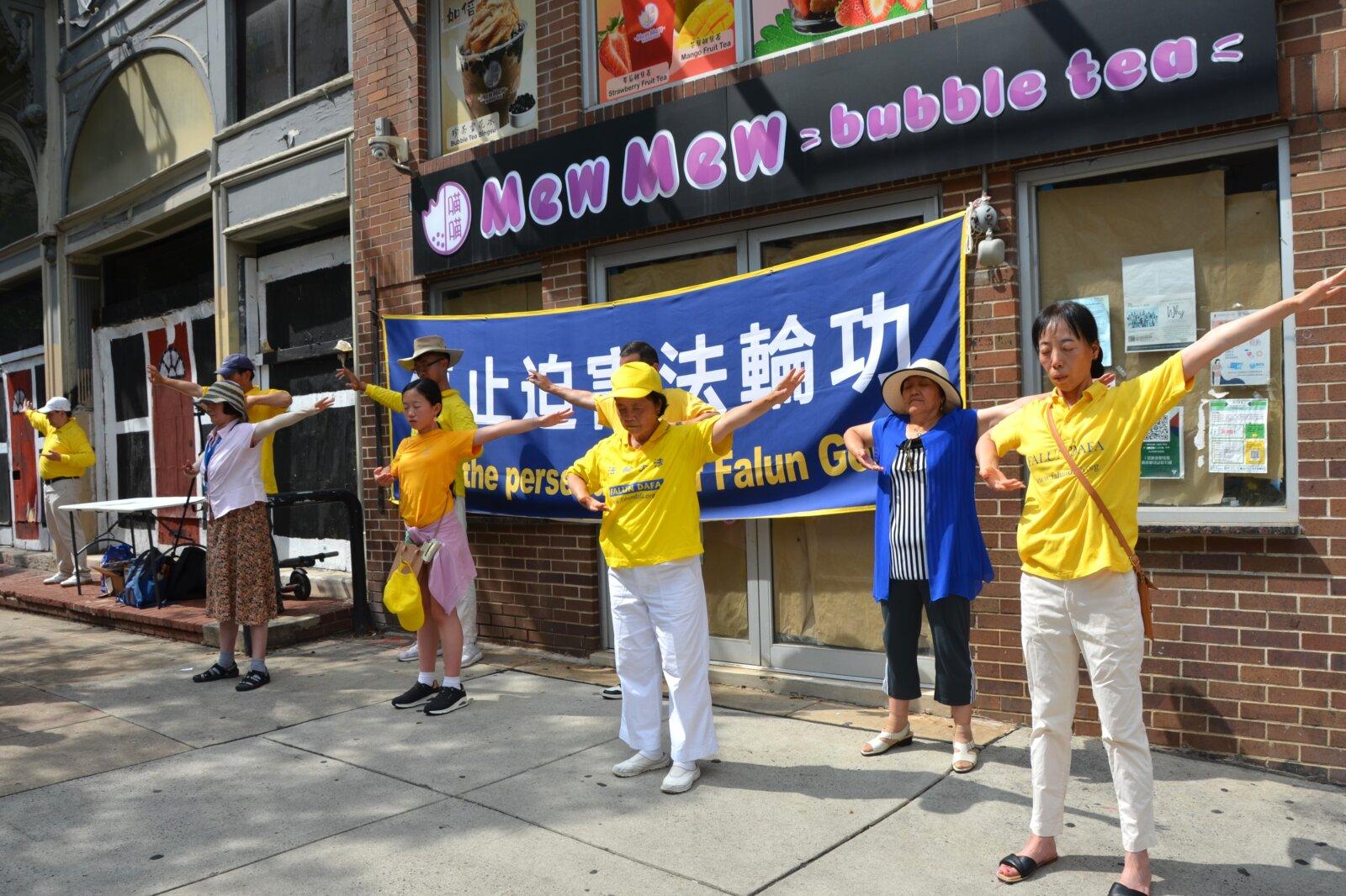 Falun Gong practitioners demonstrate Falun Gong exercises at a rally in Philadelphia Chinatown on July 20, 2025. (Frank Liang/The Epoch Times)