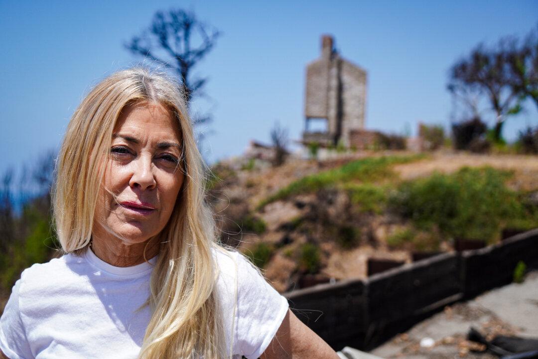 Pacific Palisades real estate developer Elaine Culotti stands in front of destroyed home on July 3, 2025. Culotti’s oceanfront home suffered significant damage in the Palisades Fire. (Allan Stein/The Epoch Times)