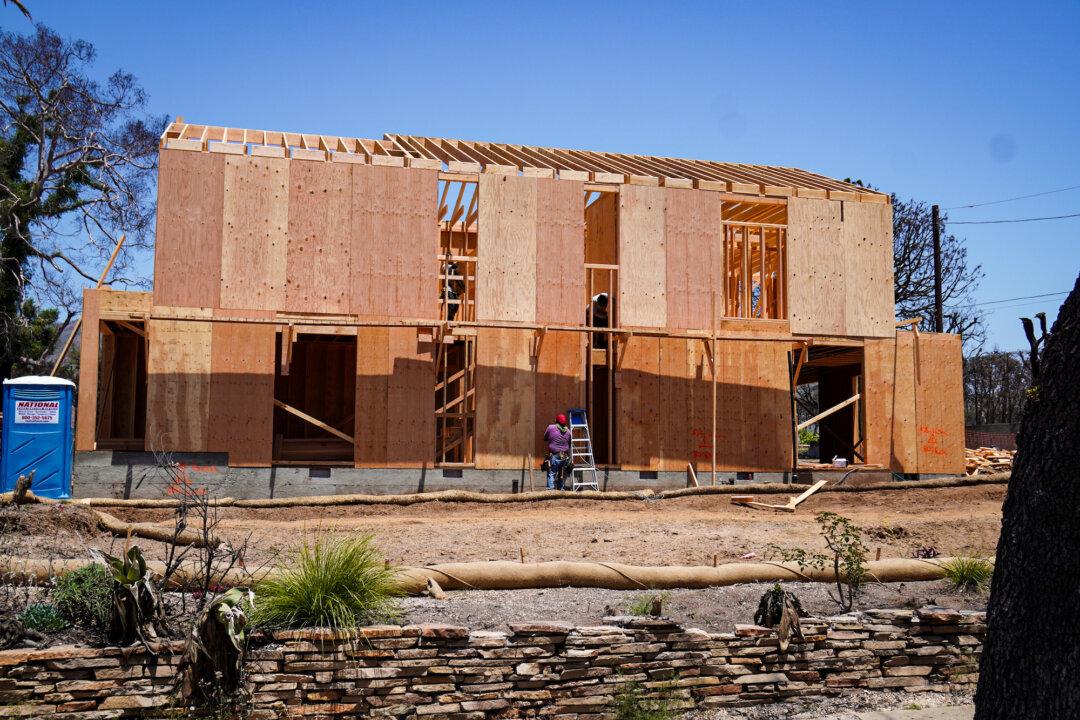 (Top) A pile of debris remains in front of a house destroyed in the Palisades Fire in Los Angeles, on July 3, 2025. The Los Angeles mayor said more than 300 tons of hazardous materials were removed in the first 28 days of clean up. (Bottom) One of a handful of new homes under construction in Pacific Palisades, Calif., on July 3, 2025. By July 21, nearly 1,200 applications for rebuilding had been received and 116 building permits issued for properties damaged or destroyed in the fires. (Allan Stein/The Epoch Times)