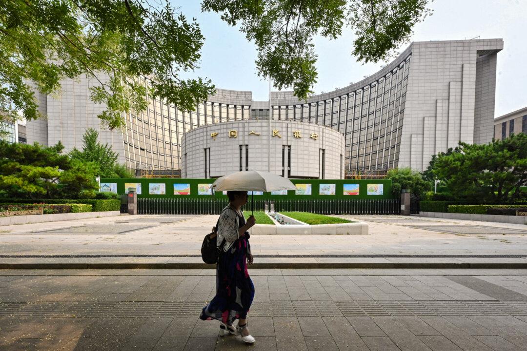 A woman walks past the headquarters of the People's Bank of China in Beijing on July 9, 2024. The central bank recently warned that traditional cross-border payment systems risk being “politicized” and “weaponized” amid rising geopolitical tensions. (Adek Berry/AFP via Getty Images)