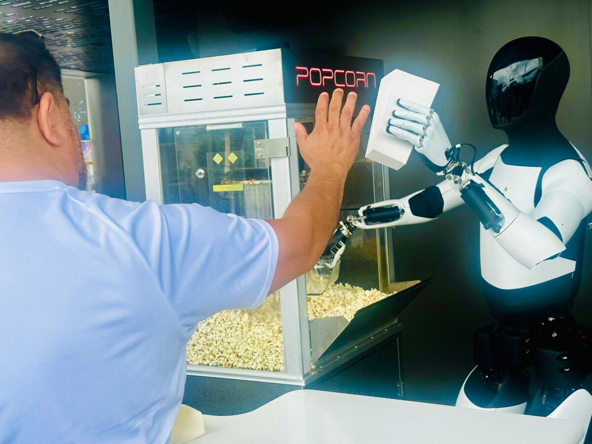 An Optimus robot serves popcorn at the Tesla Diner in Los Angeles on July 22, 2025. (Jill McLaughlin/The Epoch Times)