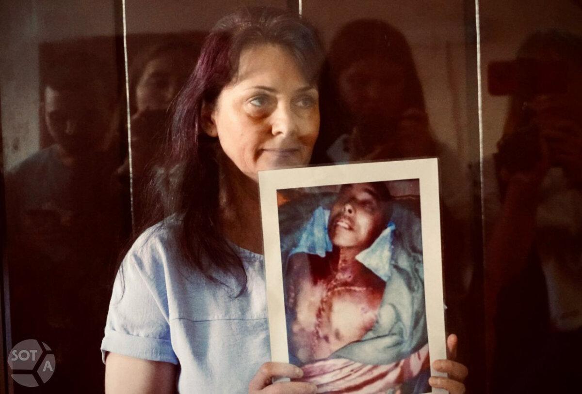 Natalya Minenkova holds a photo of a Falun Gong practitioner who was persecuted to death in China, at Minenkova's sentencing at the Tushinsky District Court of Moscow on July 23, 2025. (Courtesy of SOTAvision)