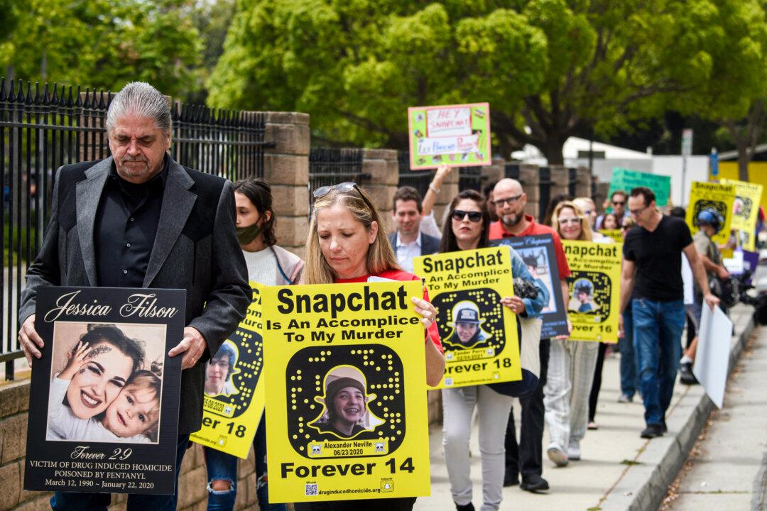 Steve Filson (L), whose daughter Jessica died of fentanyl poisoning in 2020, and Amy Neville (R) join a march to protest outside Snap Inc. headquarters in Santa Monica, Calif., on June 4, 2021. The group called for stronger parental controls on the Snapchat app, better tools to block illegal drug sales, and greater cooperation with law enforcement. (Patrick T. Fallon/AFP via Getty Images)