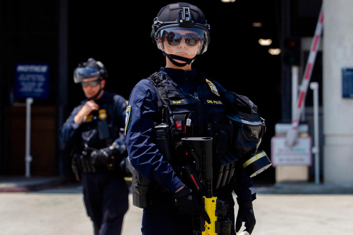 Department of Homeland Security (DHS) officers stand guard in front of the Edward R. Roybal Federal building and Detention Center while demonstrators protest in Los Angeles on Aug. 2, 2025. (Apu Gomes/Getty Images)