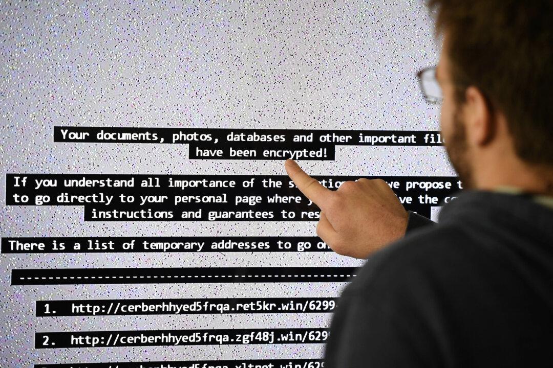 An IT researcher displays a ransomware-infected computer at the High Security Laboratory of the National Institute for Research in Computer Science and Automation in Rennes, France, on Nov. 3, 2016. Experts say over-reliance on commercial cloud servers leaves systems more exposed to cyberattacks. (Damien Meyer/AFP via Getty Images)