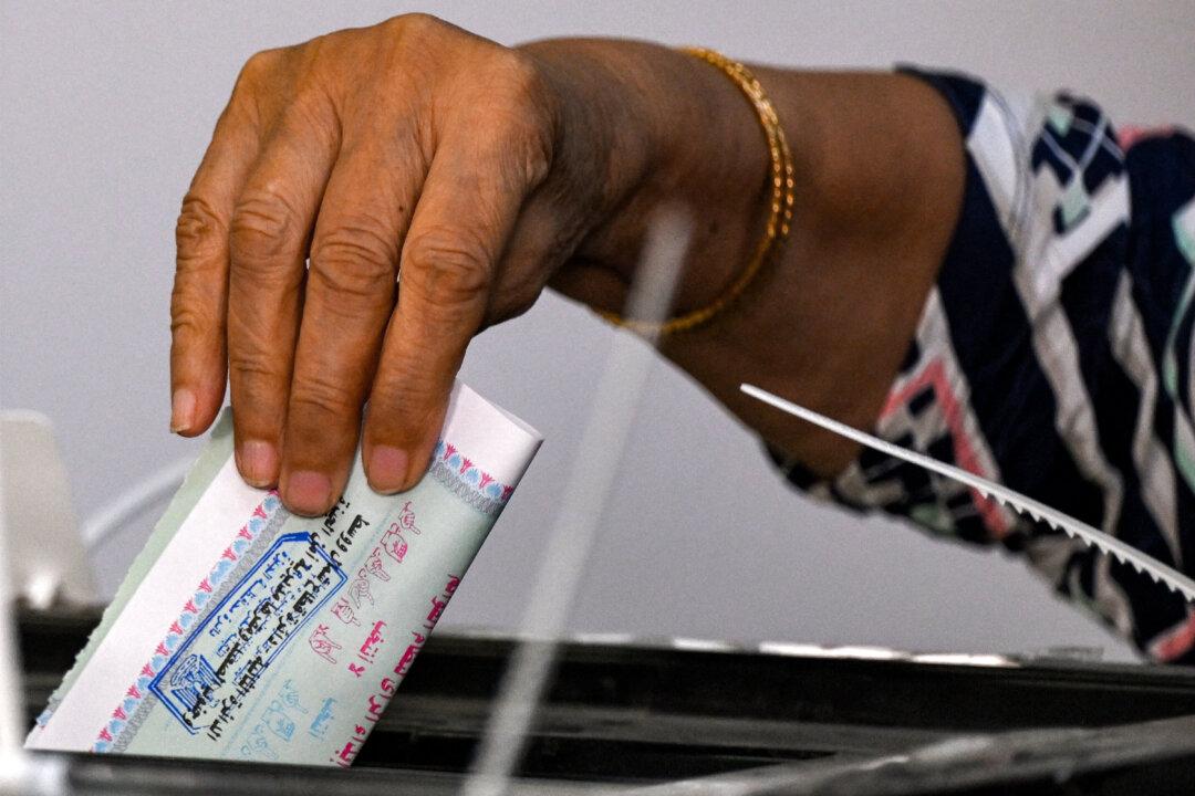A voter casts her ballot at a polling station in a school in the district of Agouza in the Egyptian capital's twin city of Giza on the first day of the 2025 Egyptian Senate elections on Aug. 4, 2025. (Khaled Desouki/AFP via Getty Images)
