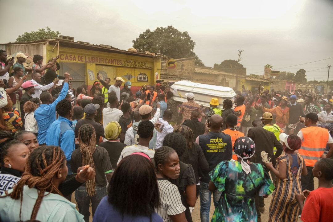 Pallbearers carry the casket of Silvia Mubiala past the place where she was shot and killed during a protest last week in Luanda, on Aug. 4, 2025. The mother of six was allegedly shot by police while trying to protect her son during a protest against a fuel price hike that claimed the lives of at least 30 people. (AFP via Getty Images)