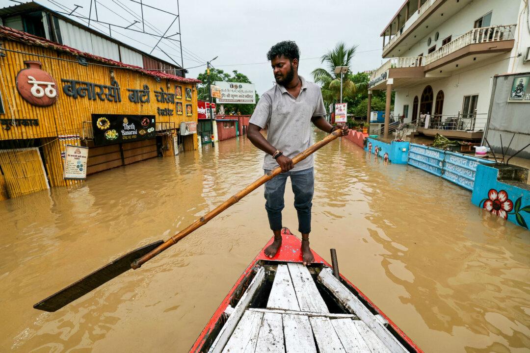 A man rows a boat along a flooded street after heavy monsoon rains caused the water levels to rise in the Ganges river in Varanasi, India, on Aug. 4, 2025. (Niharika Kulkarni/AFP via Getty Images)
