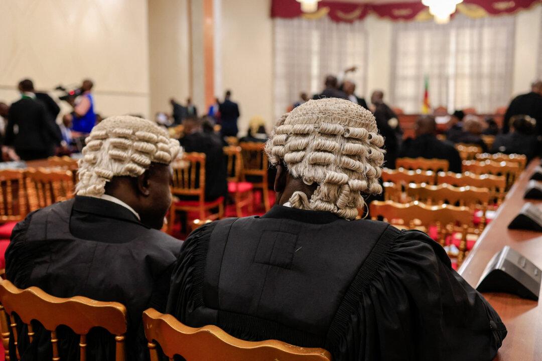 Lawyers talk in the courtroom of the Constitutional Council before the start of appeals from unsuccessful election candidates in Yaounde, Cameroon, on Aug. 4, 2025. The candidates were excluded by electoral authorities from the list of candidates approved to run in an Oct. 12 presidential vote. (AFP via Getty Images)