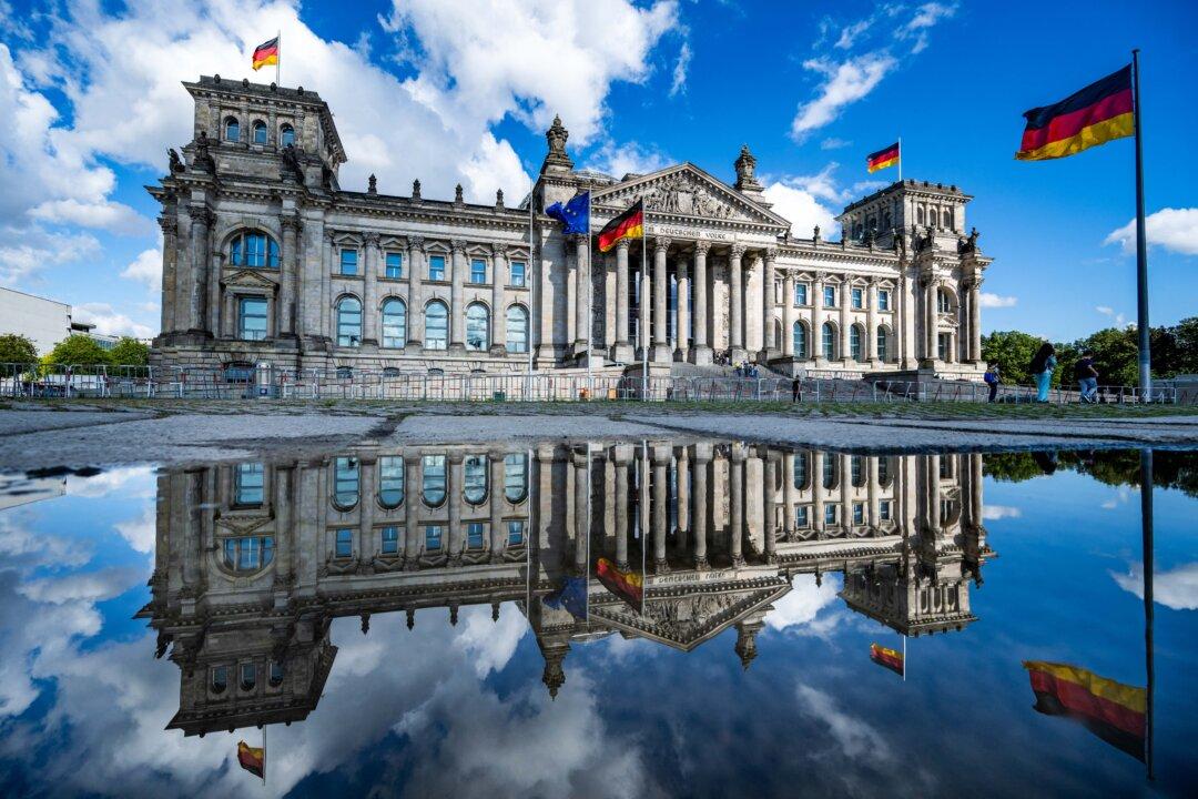 The Reichstag building, which houses Germany's lower house of parliament (Bundestag), is reflected in a puddle after a downpour in Berlin, on Aug. 4, 2025. (John Macdougall/AFP via Getty Images)