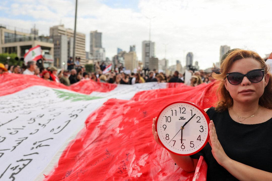 A Lebanese demonstrator carries a clock during a gathering to honor the victims of the catastrophic Beirut port explosion in 2020 and to call for accountability for the blast, on Aug. 4, 2025. (Anwar Amro/AFP via Getty Images)