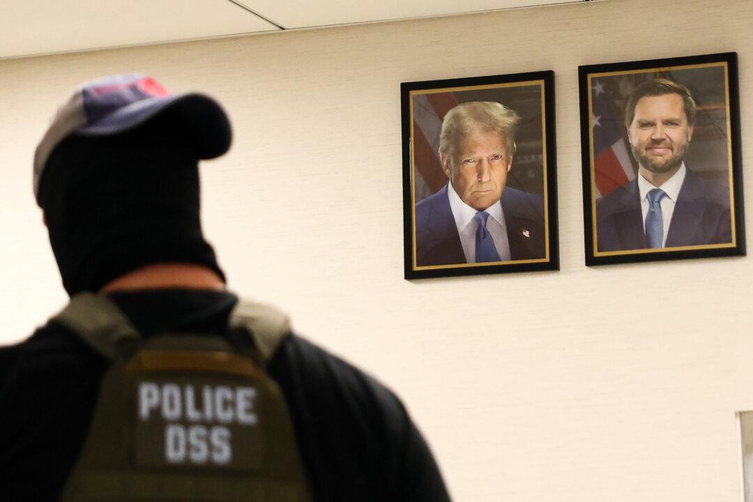 A federal agent walks past portraits of President Donald Trump and Vice President JD Vance as he patrols the halls of the Ted Weiss Federal Building in New York City on Aug. 4, 2025. The Department of Homeland Security is offering new Immigration and Customs Enforcement (ICE) recruits a signing bonus of up to $50,000 and student loan forgiveness as the agency seeks to meet Trump’s goal of hiring 10,000 new ICE agents and deporting a million people a year. (Michael M. Santiago/Getty Images)