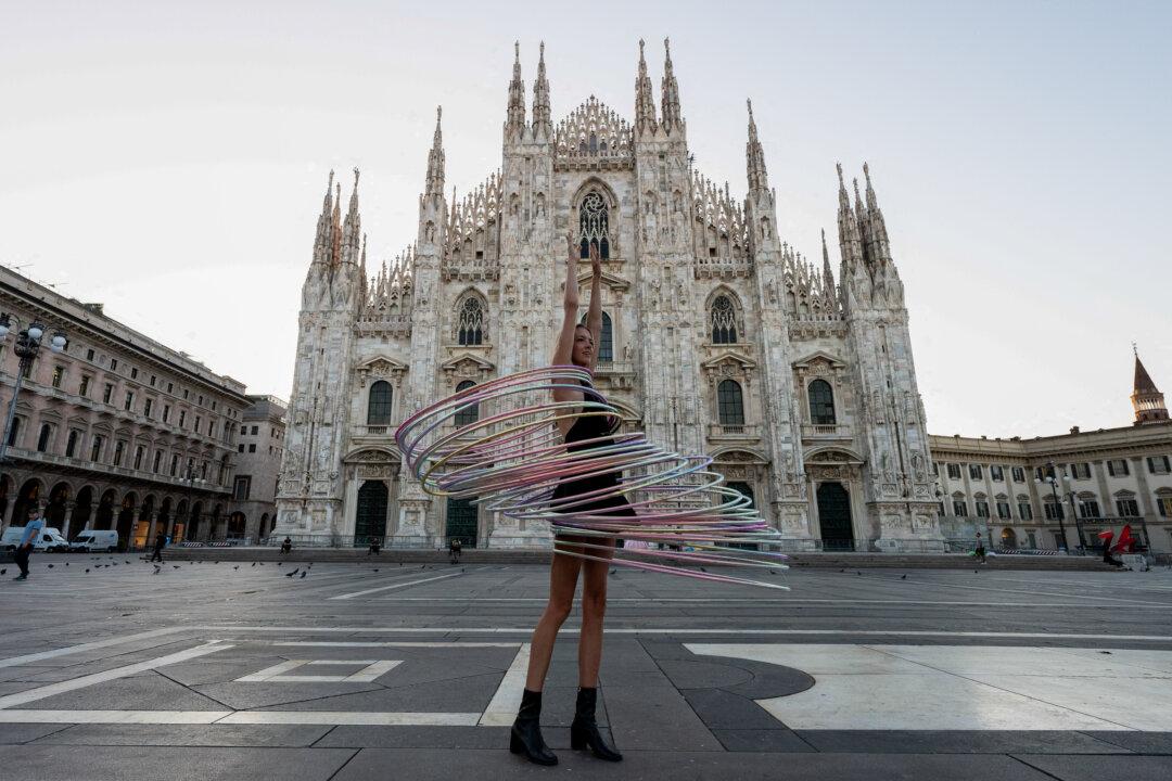 Acrobatic artist Kate Ryan hula-hoops with multiple hoops early in the morning in Piazza del Duomo (Cathedral Square) in central Milan, on Aug. 5, 2025. (Stefano Rellandini/AFP via Getty Images)