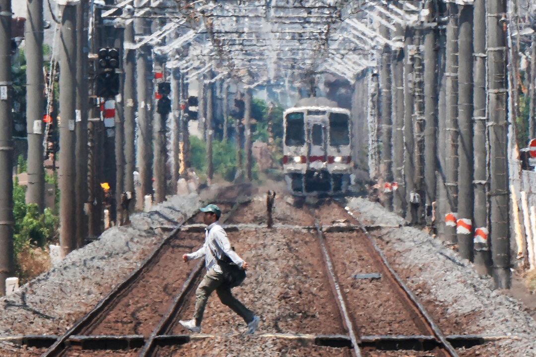 Heat haze is seen in the background while a man crosses a railroad on a hot day in Tokyo on Aug. 5, 2025. (Kazuhiro Nogi/AFP via Getty Images)