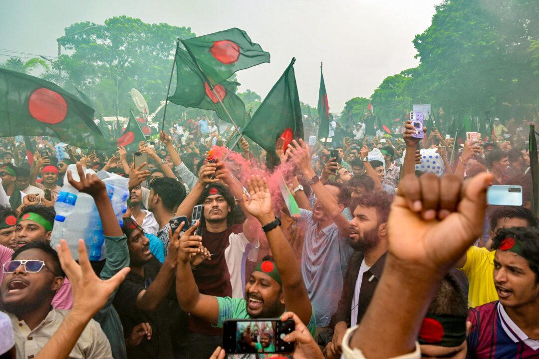 People hold Bangladesh's national flag as they celebrate during a government-organized event in Dhaka, Bangladesh, on Aug. 5, 2025. Bangladesh's interim leader marked the first anniversary since the overthrow of the autocratic regime of Sheikh Hasina by calling for reform. (Munir Uz Zaman/AFP via Getty Images)