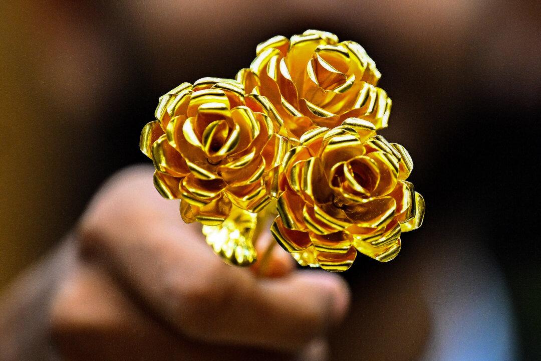 A man shows a rose-shaped, 24-karat gold piece, weighing one ounce (31.1 grams) on sale for KD 1,200 (US$4,000) at the central gold market in Kuwait City, on Aug. 5, 2025. (Yasser Al-Zayyat/AFP via Getty Images)