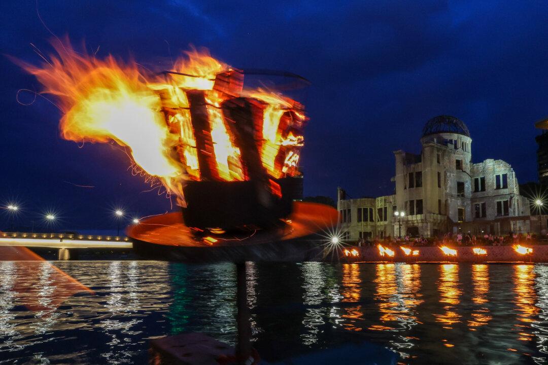 Small bonfires burn along the river ahead of the 80th anniversary activities commemorating the atomic bombing of Hiroshima at the Hiroshima Peace Memorial Park in Hiroshima, Japan, on Aug. 5, 2025. (Buddhika Weerasinghe/Getty Images)