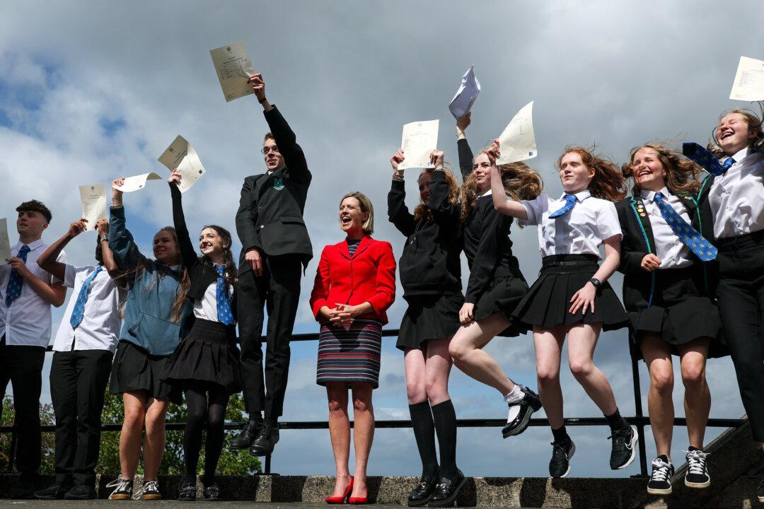 Pupils pose for a photograph after receiving exam results at King's Park Secondary School in Glasgow, Scotland, on Aug. 5, 2025. Pupils in Scotland receive their grades on Tuesday, Aug. 5. The results released by the Scottish Qualifications Authority (SQA) cover Nationals, Highers, Advanced Highers, and vocational qualifications. (Jeff J Mitchell/Getty Images)