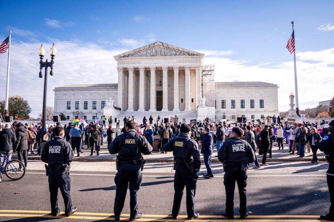 U.S. Capitol Police officers stand by as people protest over a case regarding the ban of gender-related procedures for minors, outside the Supreme Court in Washington on Dec. 4, 2024. In June, the high court upheld a Tennessee law banning transgender-related puberty blockers and hormone treatments for minors. (Madalina Vasiliu/The Epoch Times)