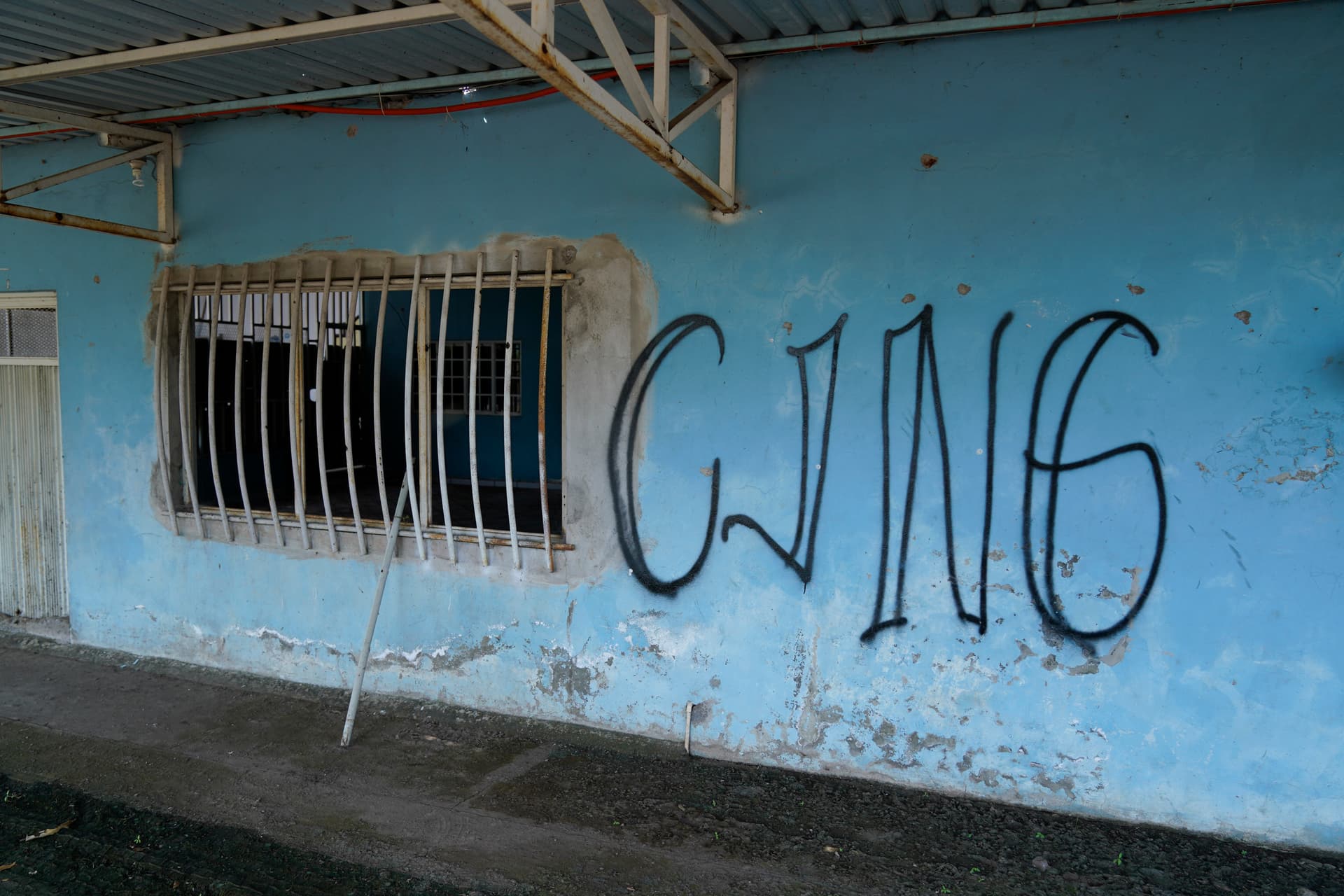 The letters "CJNG" for the cartel's formal name, Jalisco New Generation Cartel, cover the facade of an abandoned home in El Limoncito, in the Michoacan state of Mexico, on Oct. 30, 2021. (Eduardo Verdugo/AP Photo)