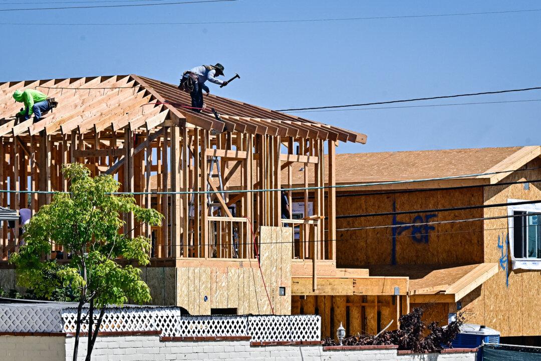 Construction workers work on the roof of a house in Alhambra, Calif., on Sept. 23, 2024. In recent years, state laws have made it easier for property owners to get accessory dwelling units approved in residential areas originally zoned for single-family homes. (Frederic J. Brown/AFP via Getty Images)