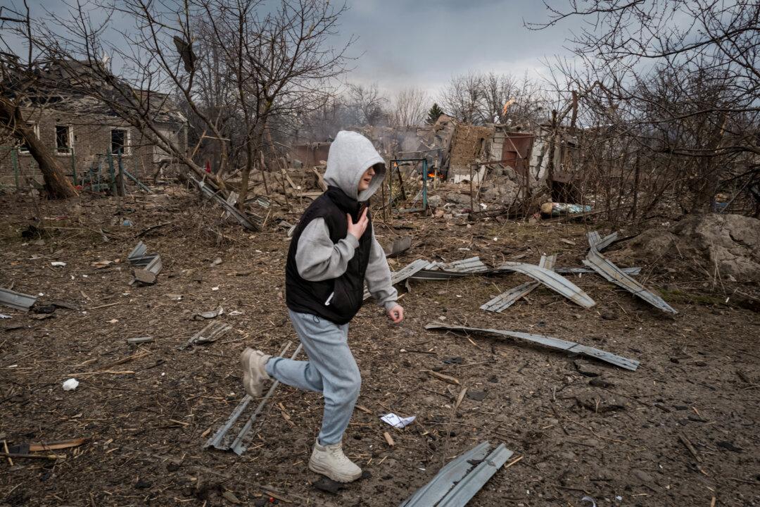 A teenager runs past a burning house destroyed by Russian bombing in a civilian residential area in the town of Kramatorsk, Ukraine, on March 22, 2025. (Philippe de Poulpiquet/Hans Lucas/AFP via Getty Images)