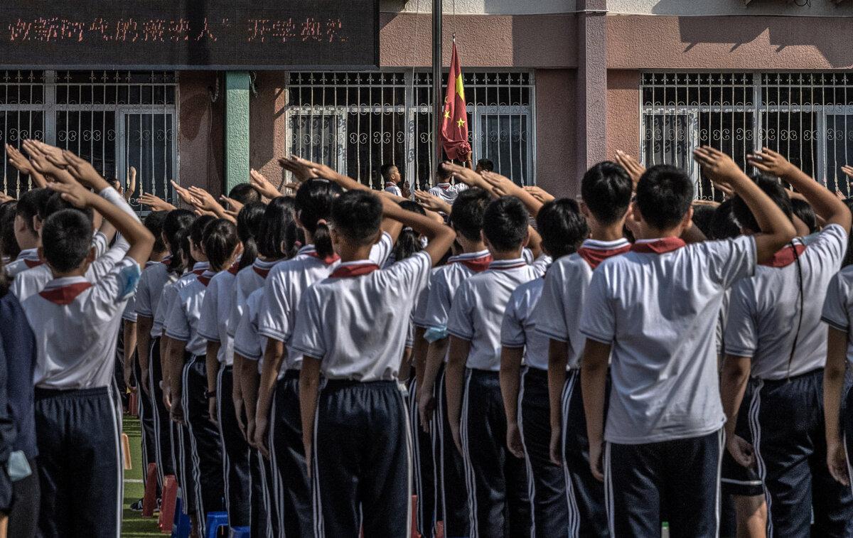 Students salute as a national flag is raised at an elementary school in Beijing on Sept. 1, 2021. (Kevin Frayer/Getty Images)