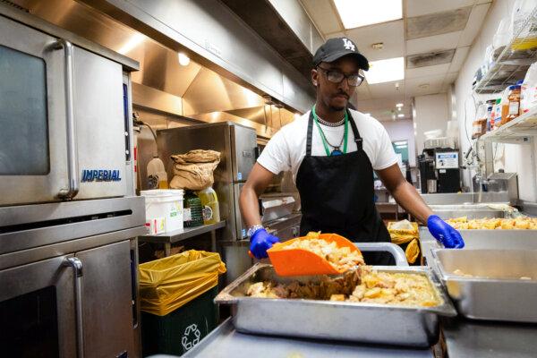 Amin Abdi, 31, prepares meals for hundreds of people at the Orange County Rescue Mission's campus in Tustin, Calif., on Aug. 18, 2025. (John Fredricks/The Epoch Times)