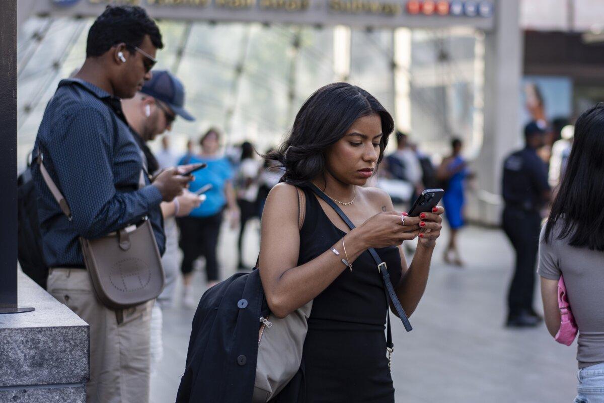 People with their phones in New York City on June 13, 2024.(Samira Bouaou/The Epoch Times)